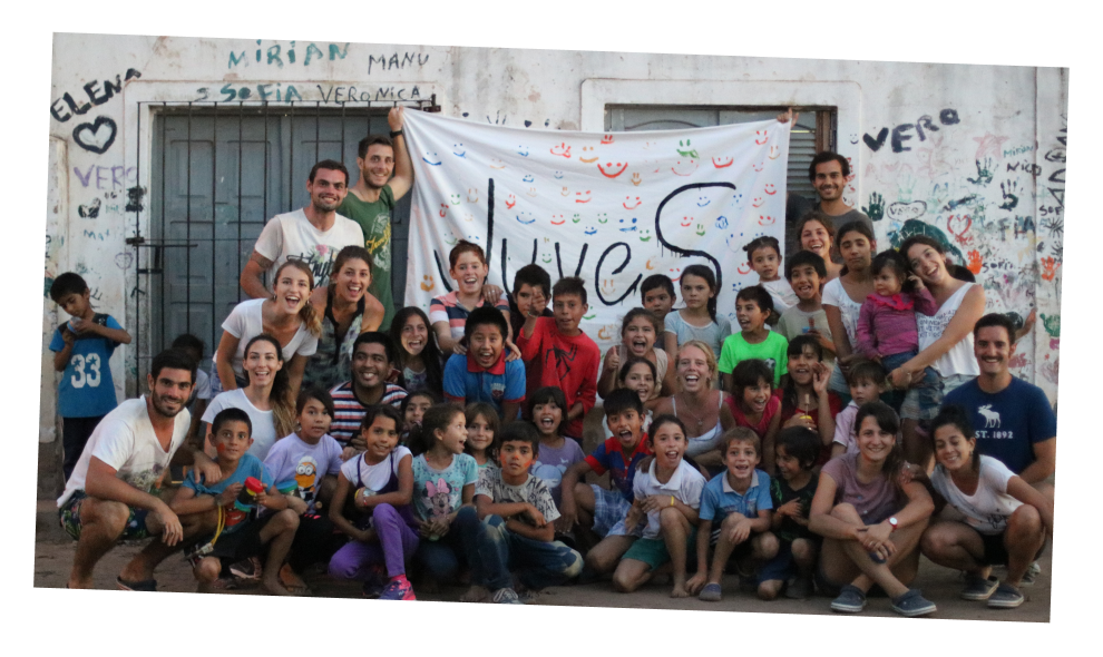 fotografia de adultos y niños sonriendo sosteniendo bandera de juves
